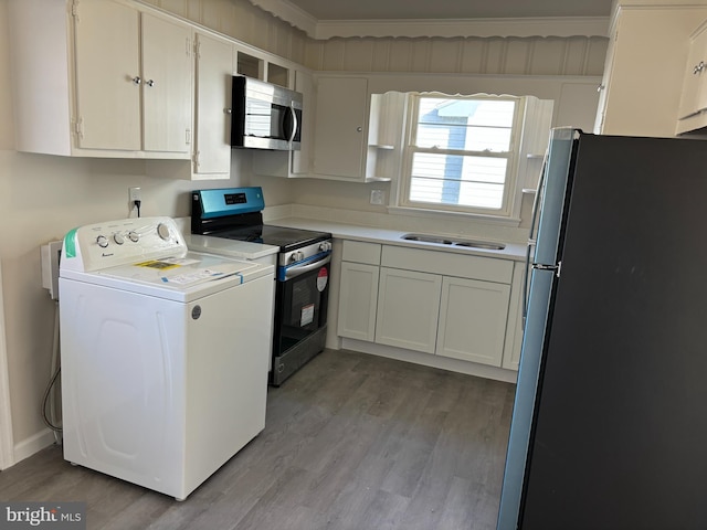 kitchen with stainless steel appliances, washer / clothes dryer, crown molding, white cabinets, and light wood-type flooring