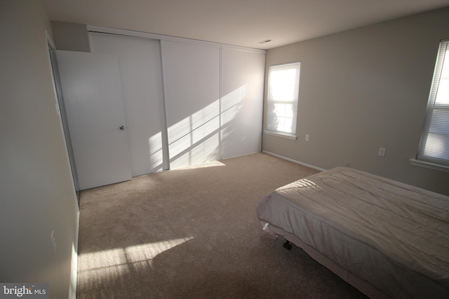 unfurnished bedroom with a closet and light carpet