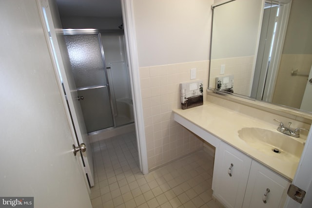 bathroom featuring tile walls, tile patterned floors, vanity, and an enclosed shower