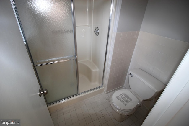 bathroom featuring toilet, walk in shower, and tile patterned floors