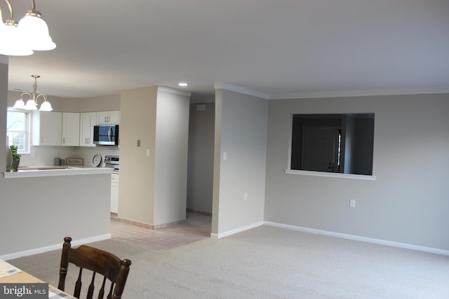 kitchen featuring pendant lighting, white cabinets, stainless steel appliances, light carpet, and an inviting chandelier