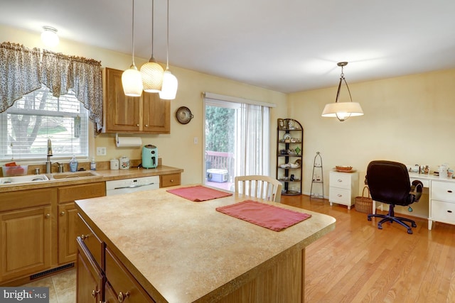 kitchen with a center island, light hardwood / wood-style floors, plenty of natural light, and sink