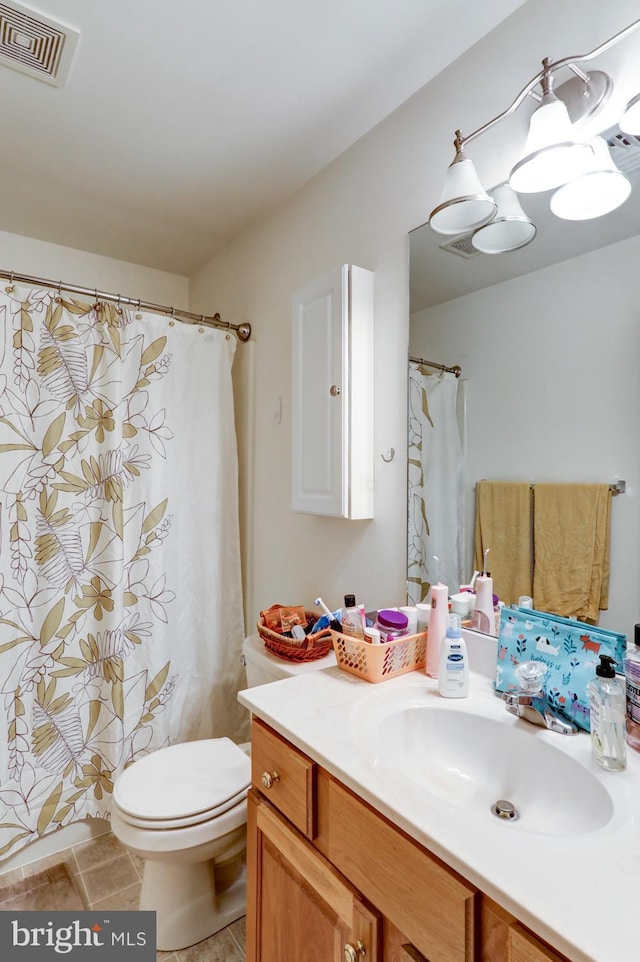 bathroom with tile patterned flooring, vanity, and toilet