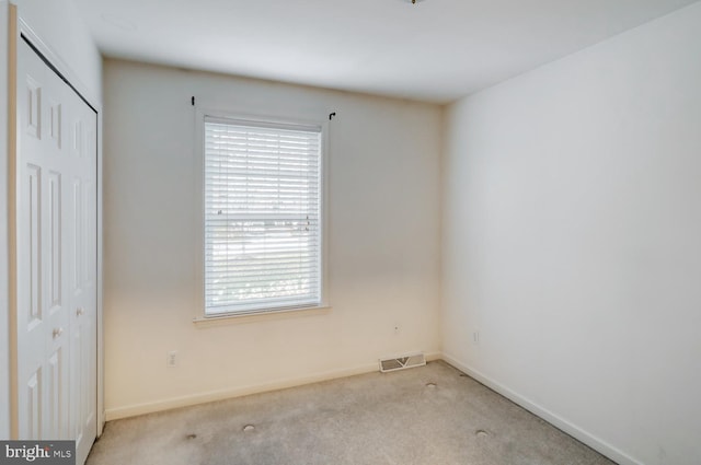 unfurnished room featuring light carpet