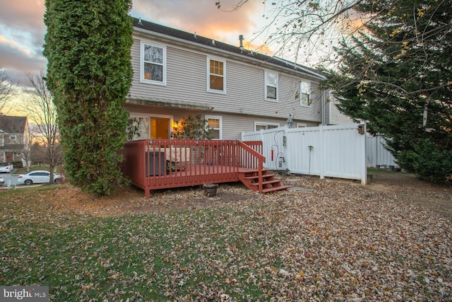 back house at dusk with a deck