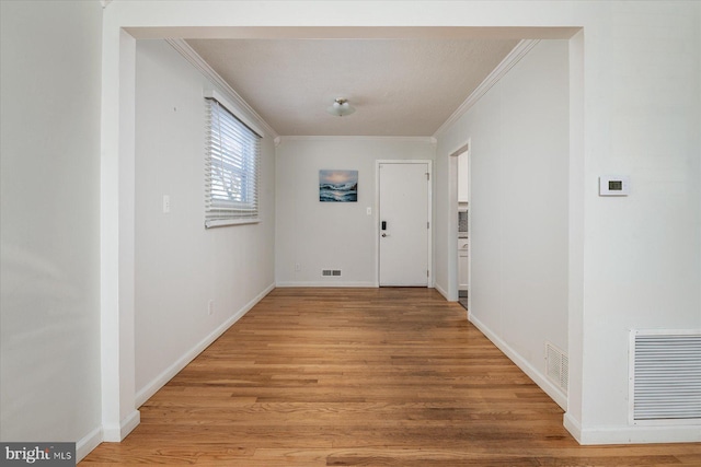 hall featuring light wood-type flooring and crown molding