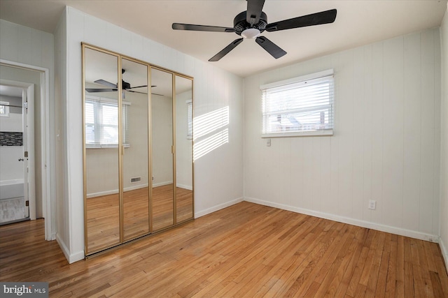 unfurnished bedroom featuring a closet, light hardwood / wood-style flooring, and ceiling fan