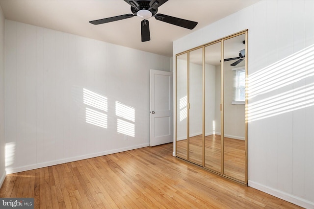 unfurnished bedroom with ceiling fan, light hardwood / wood-style floors, and a closet