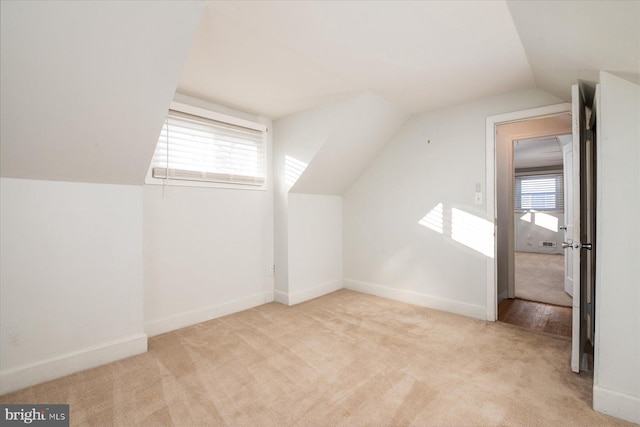 additional living space featuring light carpet and lofted ceiling