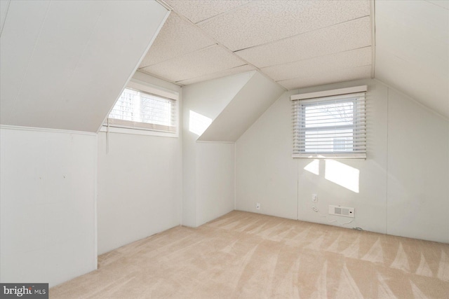 bonus room featuring light colored carpet, vaulted ceiling, and a wealth of natural light