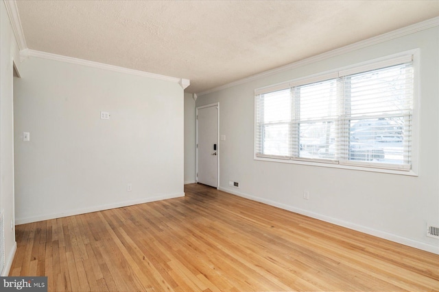 empty room with a textured ceiling, crown molding, and light hardwood / wood-style flooring