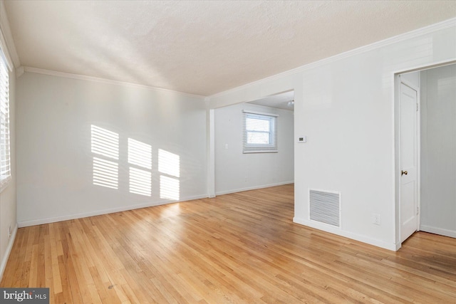 spare room with crown molding, light hardwood / wood-style flooring, and a textured ceiling