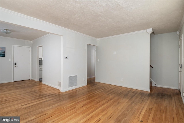 spare room with a textured ceiling, light hardwood / wood-style flooring, and crown molding