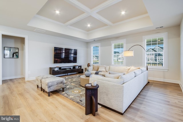 living room featuring coffered ceiling, a healthy amount of sunlight, crown molding, and light hardwood / wood-style flooring