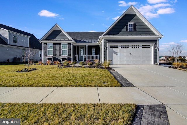 view of front of property with a porch, a front yard, and a garage