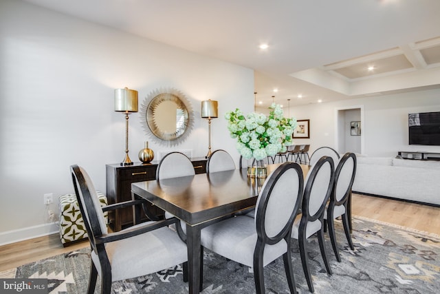 dining room featuring light wood-type flooring and coffered ceiling