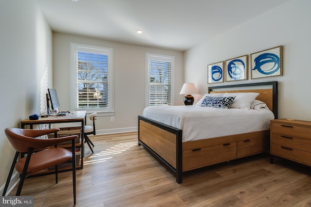 bedroom with multiple windows and light hardwood / wood-style flooring