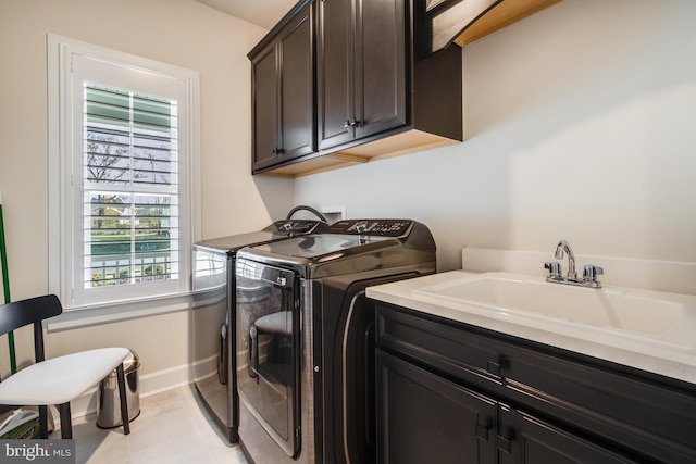 laundry area with separate washer and dryer, sink, light tile patterned flooring, and cabinets