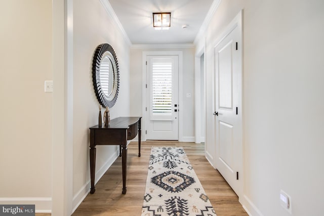 doorway featuring ornamental molding and light wood-type flooring