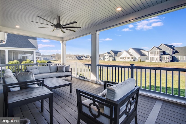 wooden terrace with ceiling fan, an outdoor hangout area, and a yard