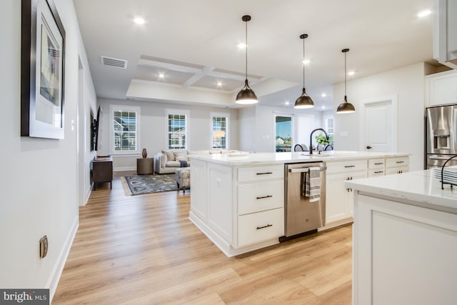 kitchen featuring a center island with sink, hanging light fixtures, light hardwood / wood-style flooring, appliances with stainless steel finishes, and white cabinetry