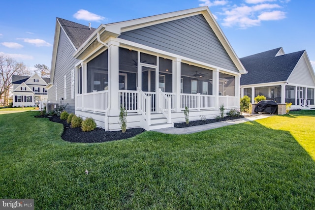 view of front of home featuring a sunroom, a front yard, and central AC