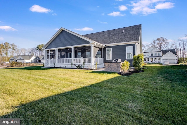 back of house with a sunroom and a lawn