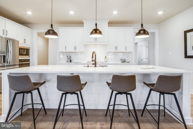 kitchen featuring stainless steel fridge with ice dispenser, hanging light fixtures, a large island, and sink