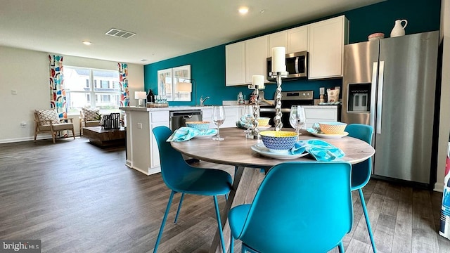 kitchen featuring white cabinetry, a kitchen island, stainless steel appliances, and dark hardwood / wood-style floors