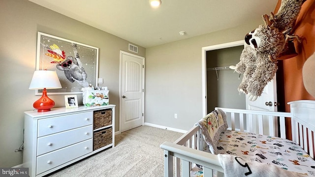 carpeted bedroom featuring a nursery area and a closet