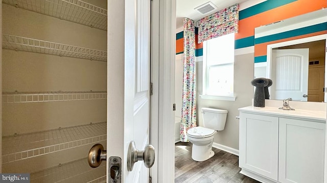 full bathroom featuring shower / bath combo with shower curtain, hardwood / wood-style floors, vanity, and toilet