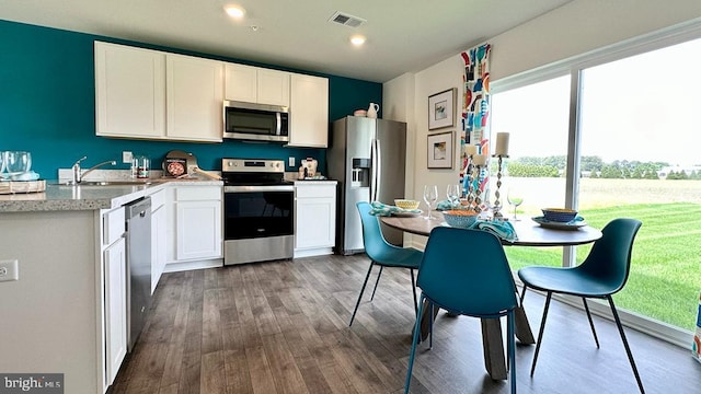 kitchen featuring hardwood / wood-style floors, sink, white cabinetry, and stainless steel appliances