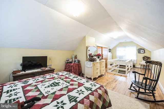 bedroom with hardwood / wood-style flooring and vaulted ceiling