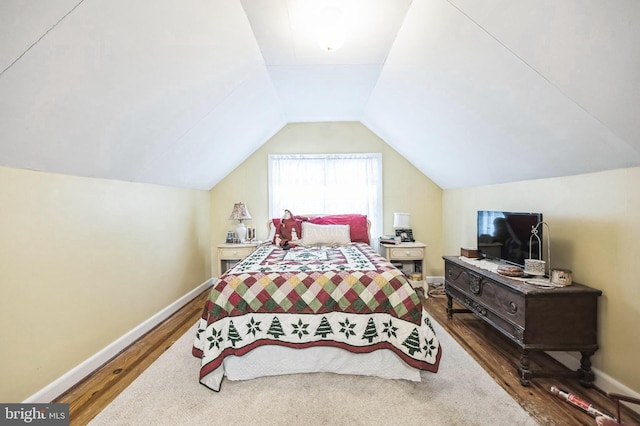 bedroom featuring dark hardwood / wood-style flooring and vaulted ceiling