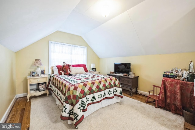 bedroom with vaulted ceiling and hardwood / wood-style flooring