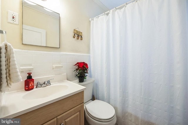 bathroom with vanity, toilet, and tile walls