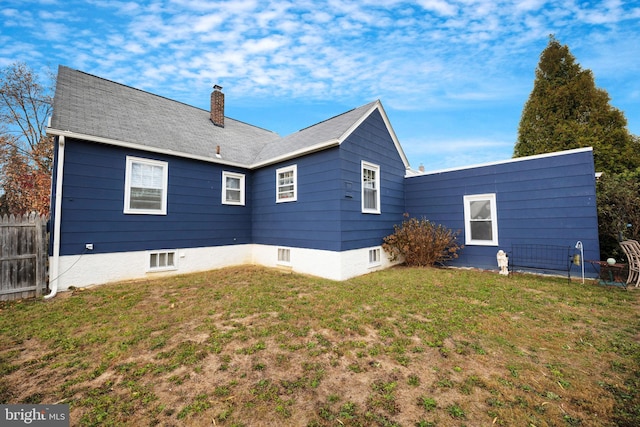 rear view of house featuring a yard