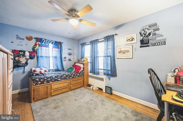 bedroom with radiator, ceiling fan, and hardwood / wood-style flooring