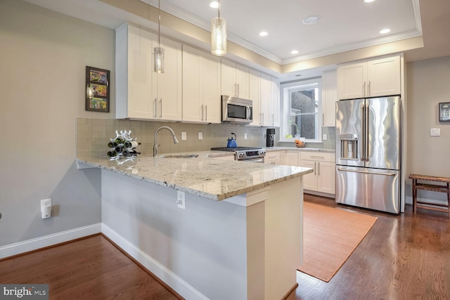 kitchen with kitchen peninsula, appliances with stainless steel finishes, dark wood-type flooring, white cabinetry, and hanging light fixtures