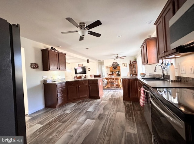 kitchen with kitchen peninsula, appliances with stainless steel finishes, ceiling fan, sink, and dark hardwood / wood-style floors