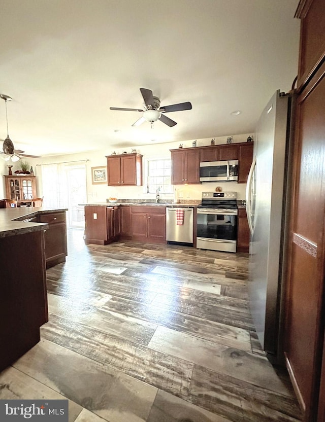 kitchen featuring a healthy amount of sunlight, sink, stainless steel appliances, and dark hardwood / wood-style floors