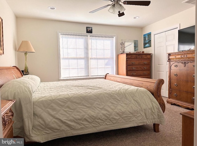 carpeted bedroom with ceiling fan and a closet