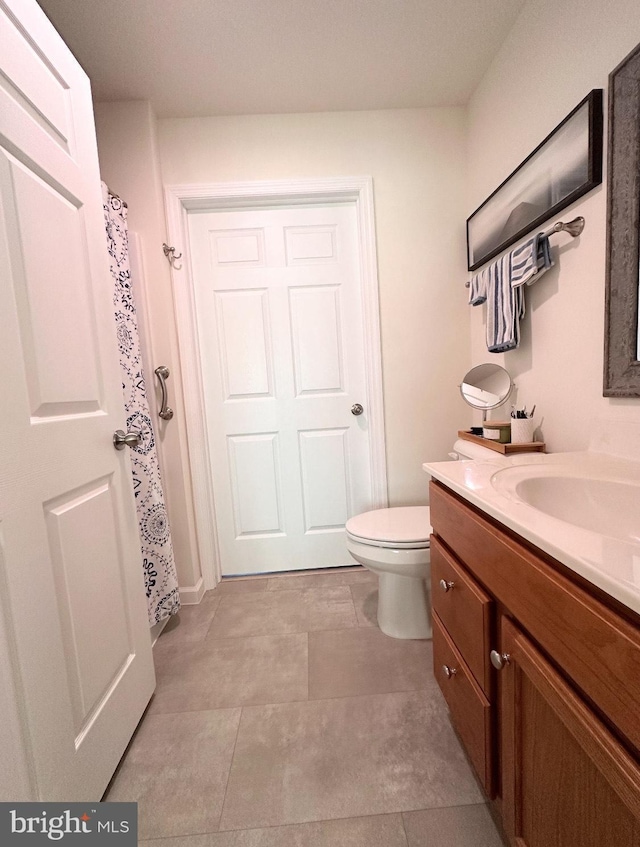 bathroom featuring tile patterned floors, vanity, and toilet