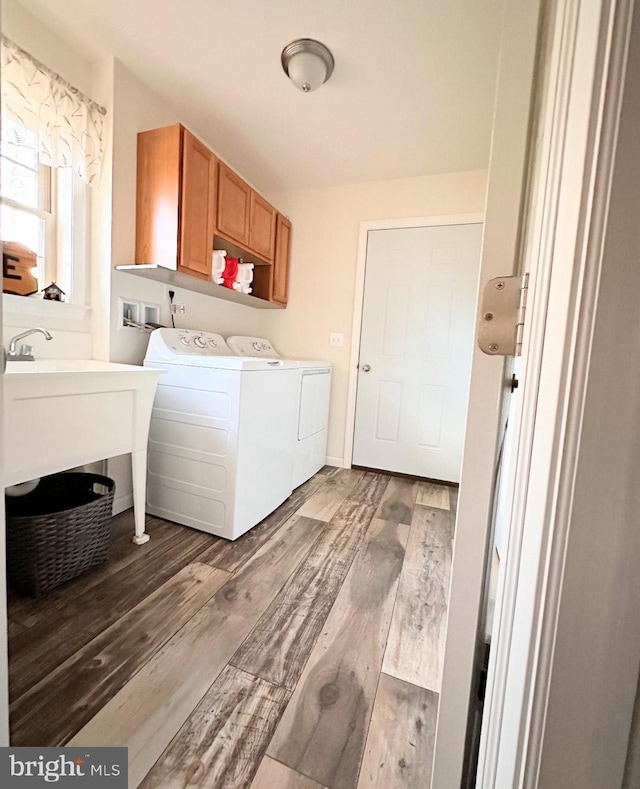 clothes washing area featuring cabinets, dark wood-type flooring, and washing machine and dryer