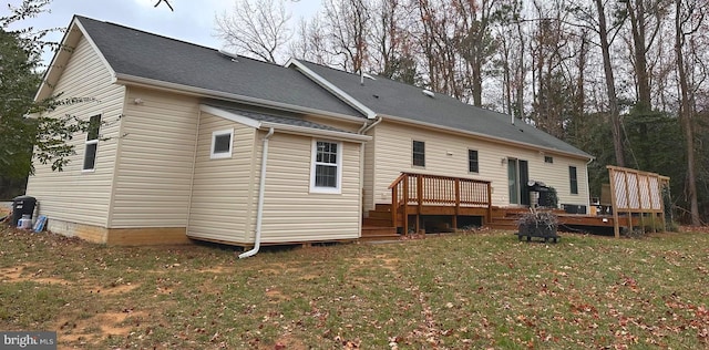 rear view of house featuring a lawn and a wooden deck