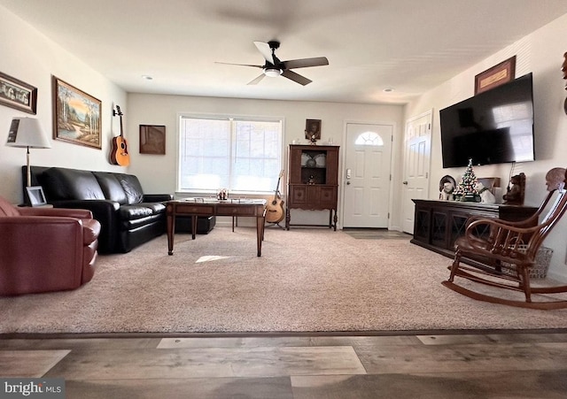 carpeted living room with ceiling fan