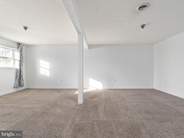 empty room featuring carpet, visible vents, and baseboards