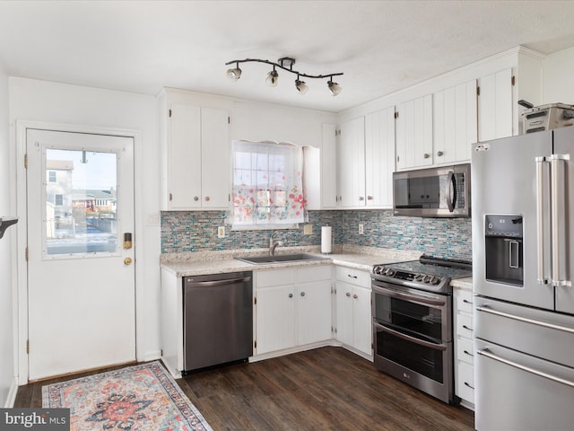 kitchen featuring stainless steel appliances, white cabinets, light countertops, and dark wood-type flooring