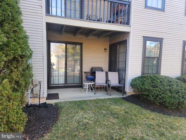 exterior space featuring a patio, a balcony, and a lawn