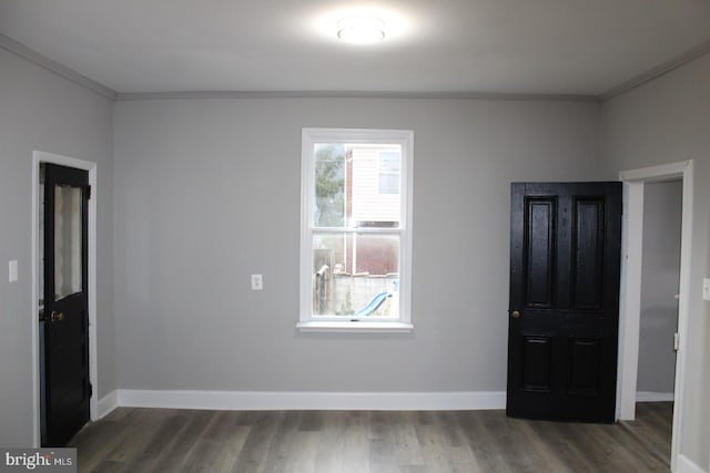 unfurnished room with dark hardwood / wood-style flooring and crown molding